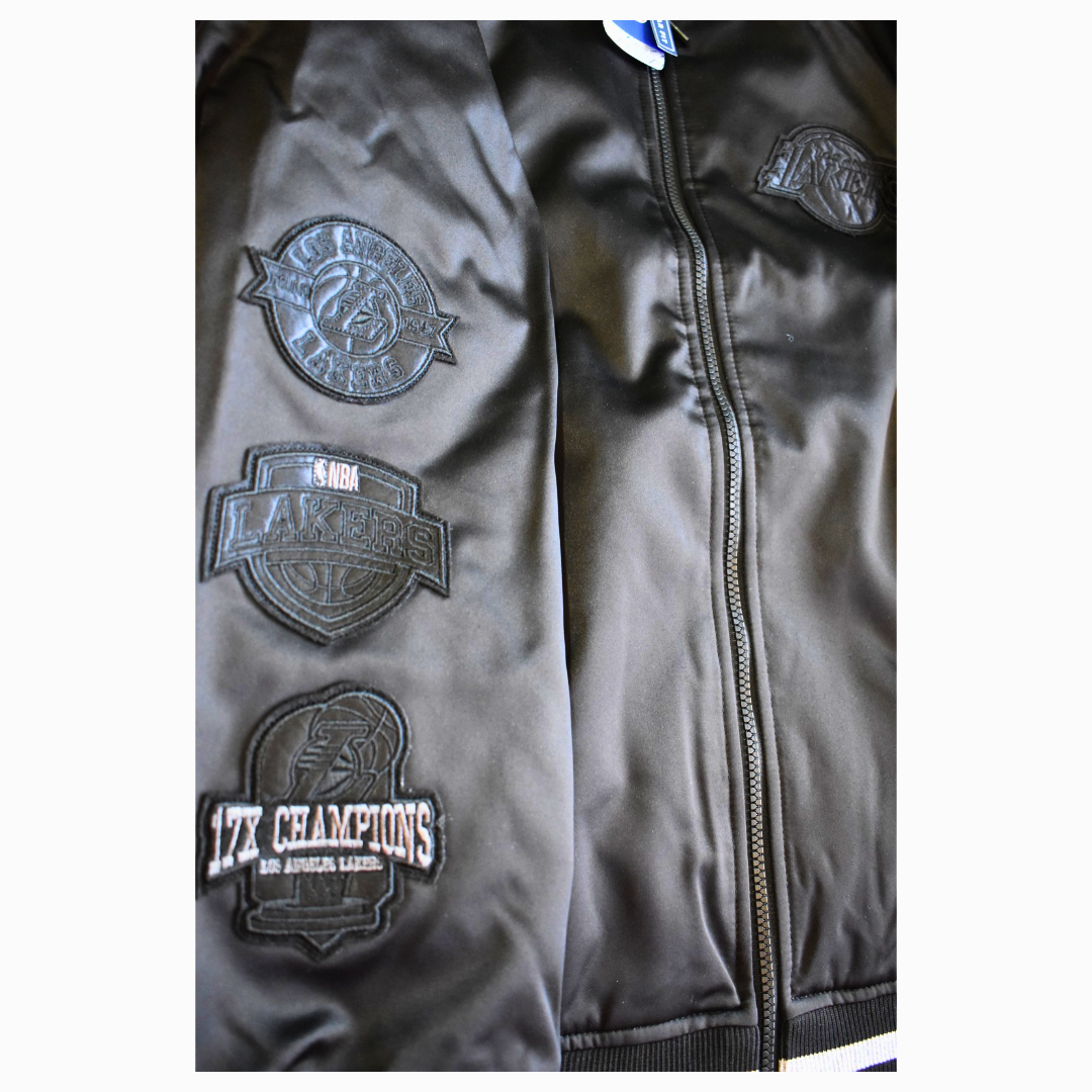 Detalle de los parches 17X Champions en la manga de la chaqueta Lakers Blackout.