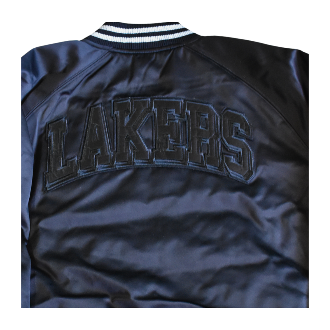 Detalle de los parches 17X Champions en la manga de la chaqueta Lakers Blackout.